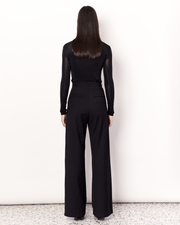 The Pleat Front Pant are an easy-wearing wide leg pant featuring a hidden clasp closure, pockets, and pleated detailing down the front, creating a subtle drape in the leg. They are crafted from a soft wool blend in Black. Now available at Romy. 