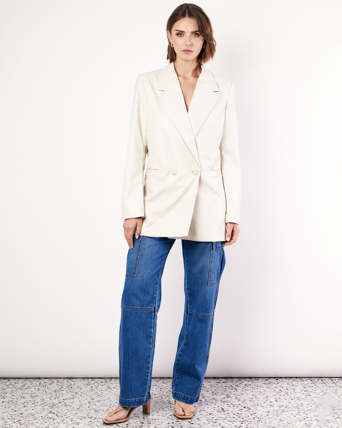 The Vegan Leather Boxy Blazer is a relaxed, oversized silhouette, featuring front pockets and a button closure. It is fully lined and is crafted from a buttery soft Vegan leather fabrication in Cream. Now available at Romy. 