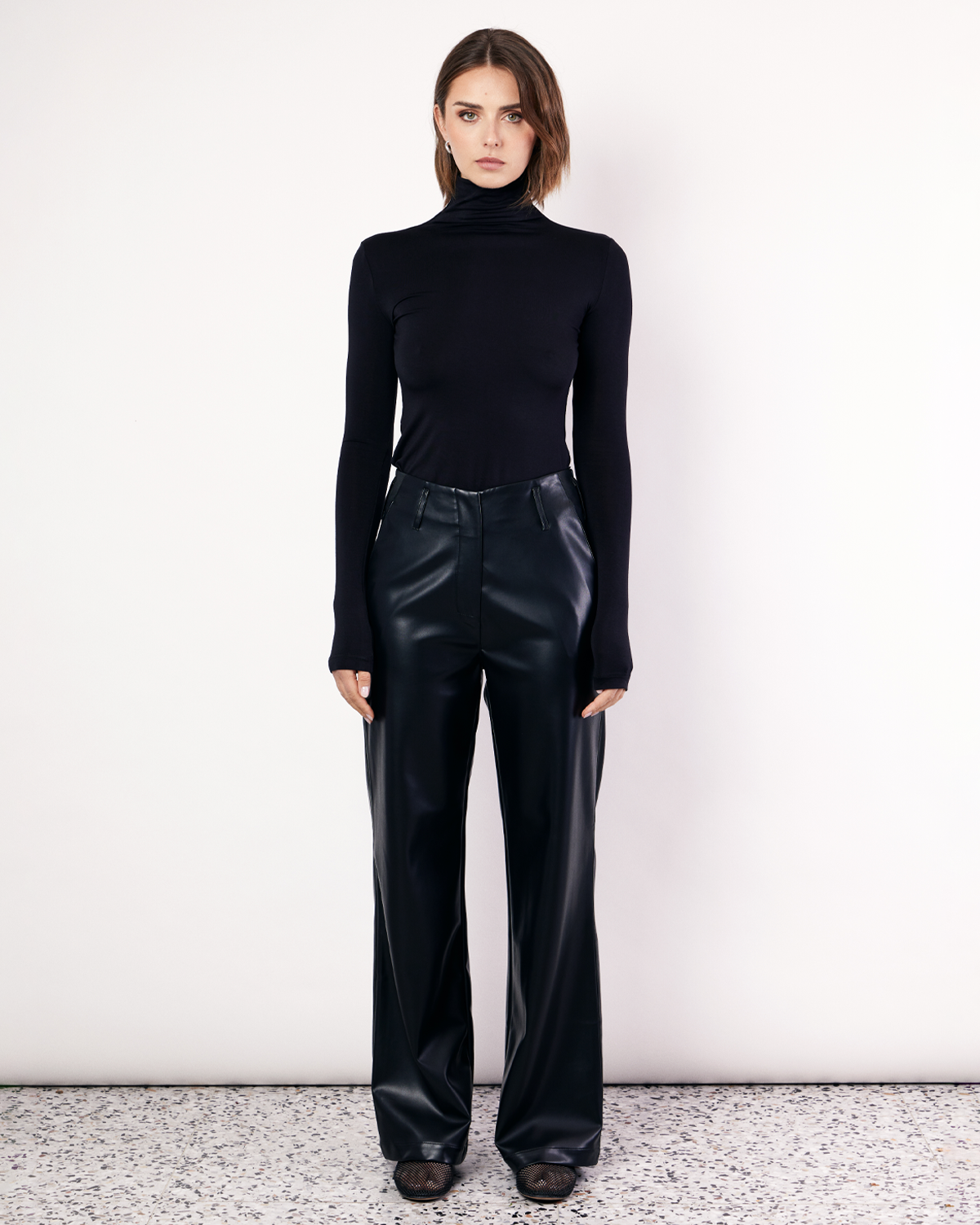 The Vegan Leather Pant are a mid-rise straight leg pant, featuring pockets, belt loops and a hidden clasp closure. They are crafted from a buttery soft Vegan Leather fabrication in Black. Now available at Romy. 