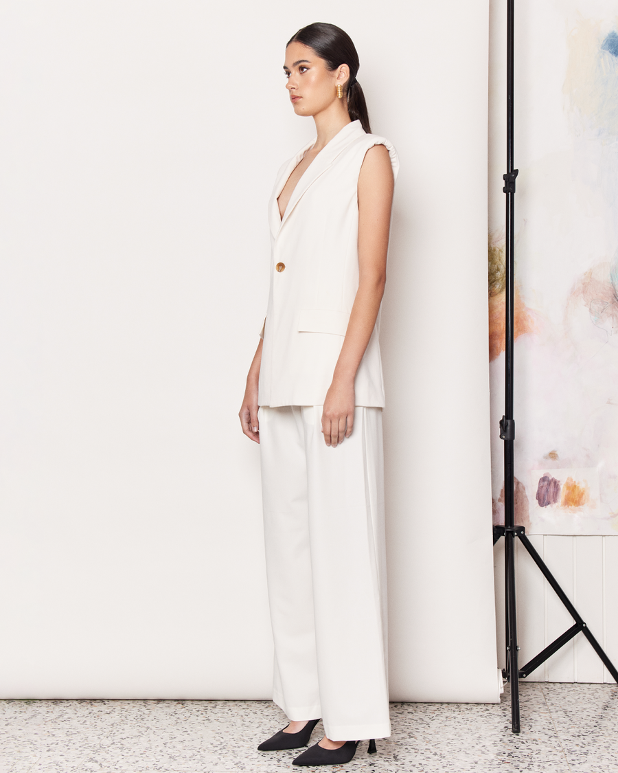 The Sleeveless Blazer is a warm weather adaptation of the Classic Blazer, with a slightly oversized fit in a light cream colourway. Crafted with a soft wool blend and fully lined in viscose, the sleeveless blazer features a deep collar, two front pocket flaps and a single button closure.