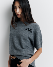 Shop the Cleo Short Sleeve Sweater made from a luxurious 90% wool and 10% cashmere blend. Featuring a relaxed fit, dropped shoulders, crew neck, and ribbed hem detailing, this lightweight, breathable sweater adds comfort and style to your wardrobe. Perfect for layering or wearing on its own.
