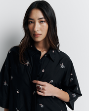 The June Shirt is an oversized short sleeve button-up featuring a concealed placket, exaggerated sleeves, and delicate floral embroidery for a subtle romantic touch. Pair it with the matching pant or wear it open over a tank for easy styling. Shop now.