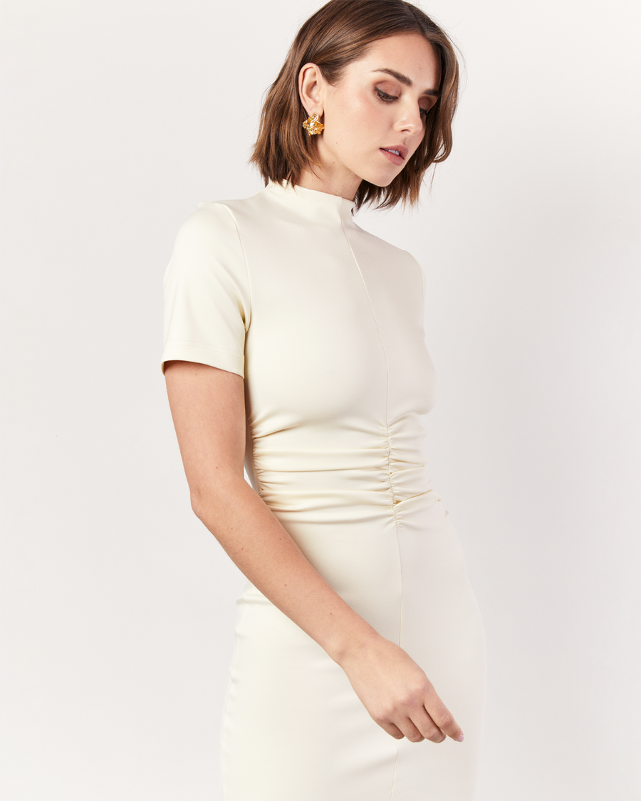 This stunning dress features a gathered front detail that adds an intriguing twist to the classic silhouette. Crafted from luxurious stretch scuba fabric, it offers a sleek and structured look that effortlessly flatters your figure and hugs you in. Now available at Romy.