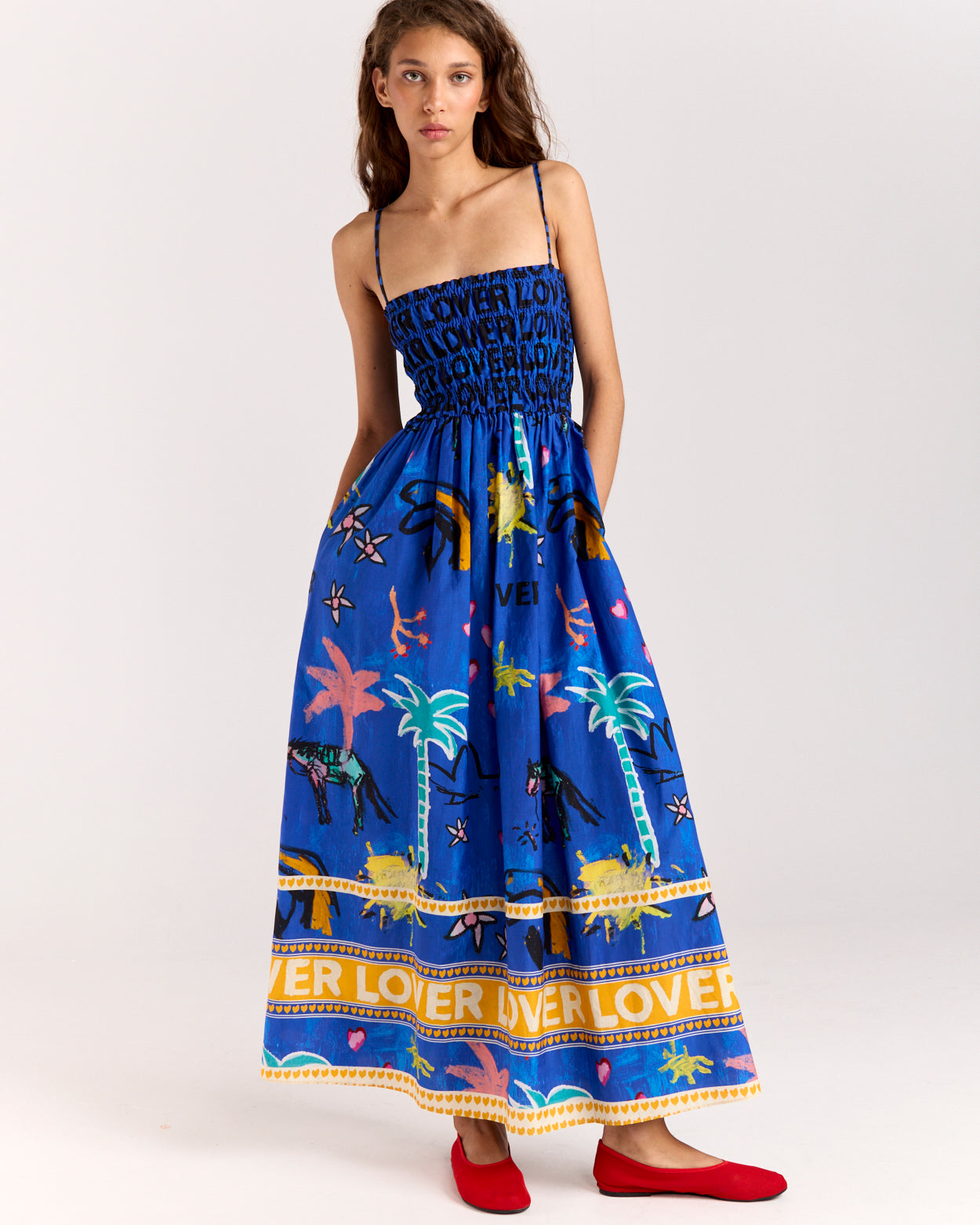 Embrace effortless summer style with the Lover Sundress, featuring Jake Pedro's exclusive Lover Print. Crafted from a breezy blend of cotton and silk, it includes adjustable straps, a flattering shirred bodice, and side pockets for added convenience.