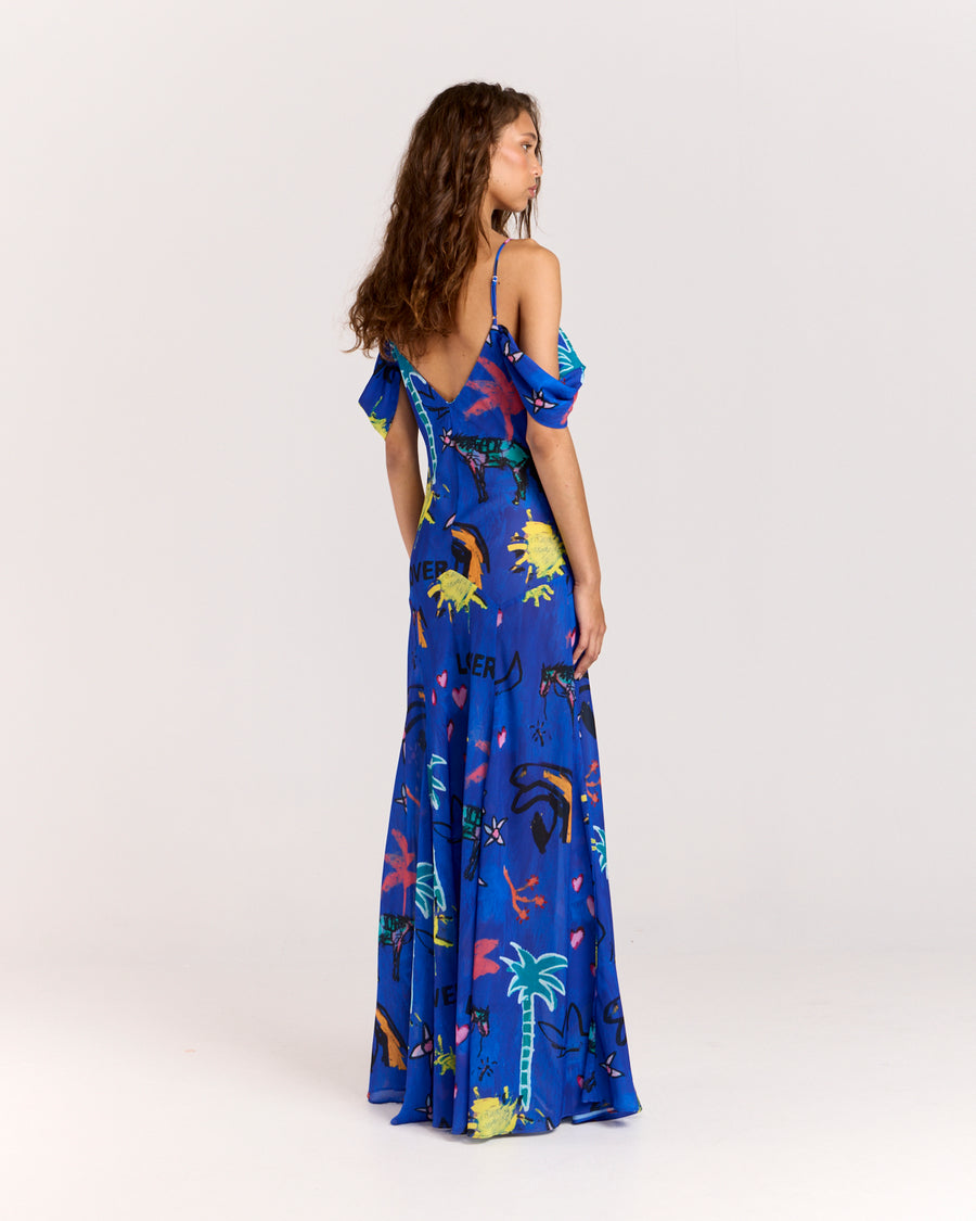 Make a bold statement with the Lover Gown, featuring Jake Pedro's exclusive Lover Print in a striking blue hue. Designed with a drop waist, adjustable straps, and a voluminous floor-length skirt, this gown offers elegance with a touch of sheerness.