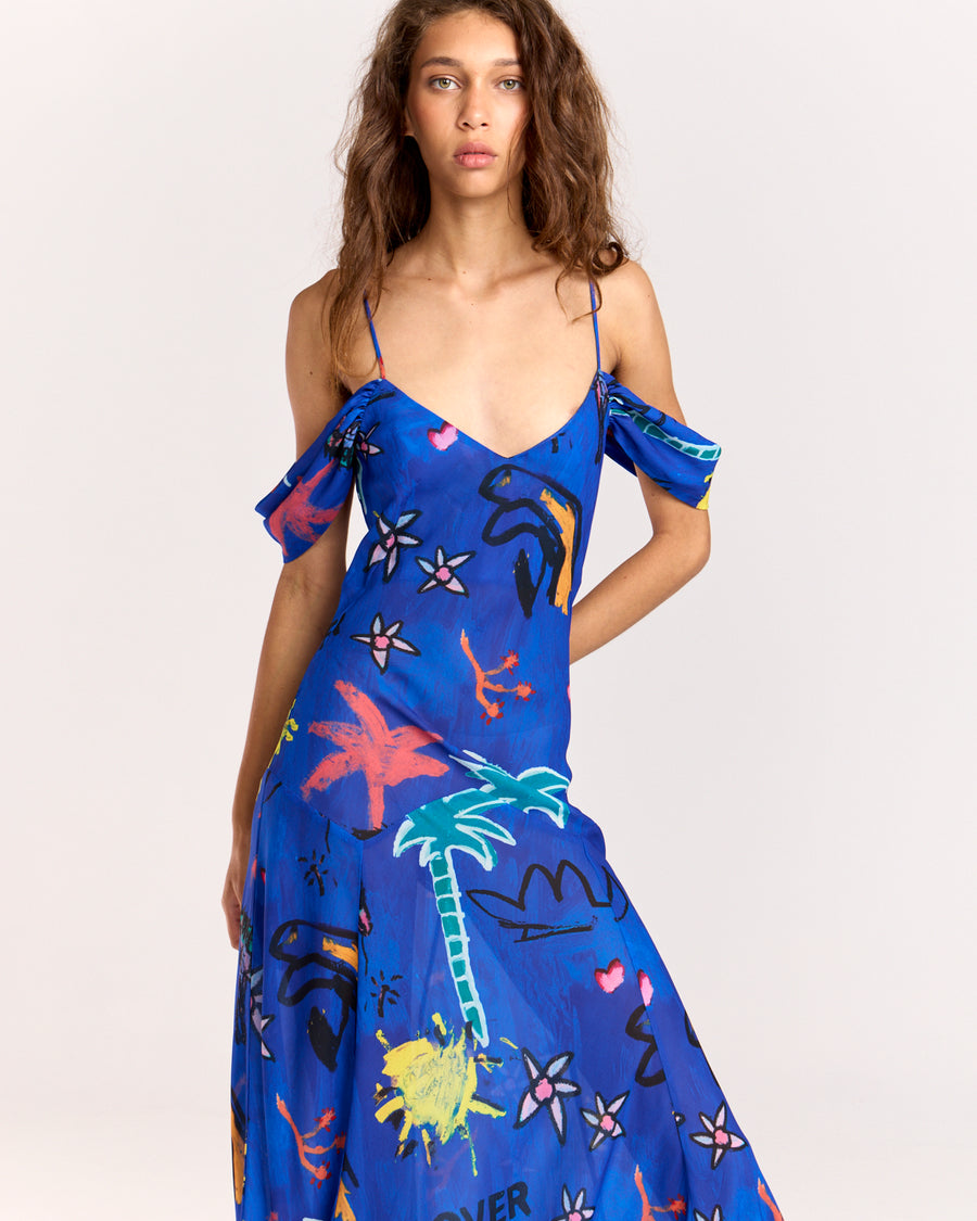 Make a bold statement with the Lover Gown, featuring Jake Pedro's exclusive Lover Print in a striking blue hue. Designed with a drop waist, adjustable straps, and a voluminous floor-length skirt, this gown offers elegance with a touch of sheerness.