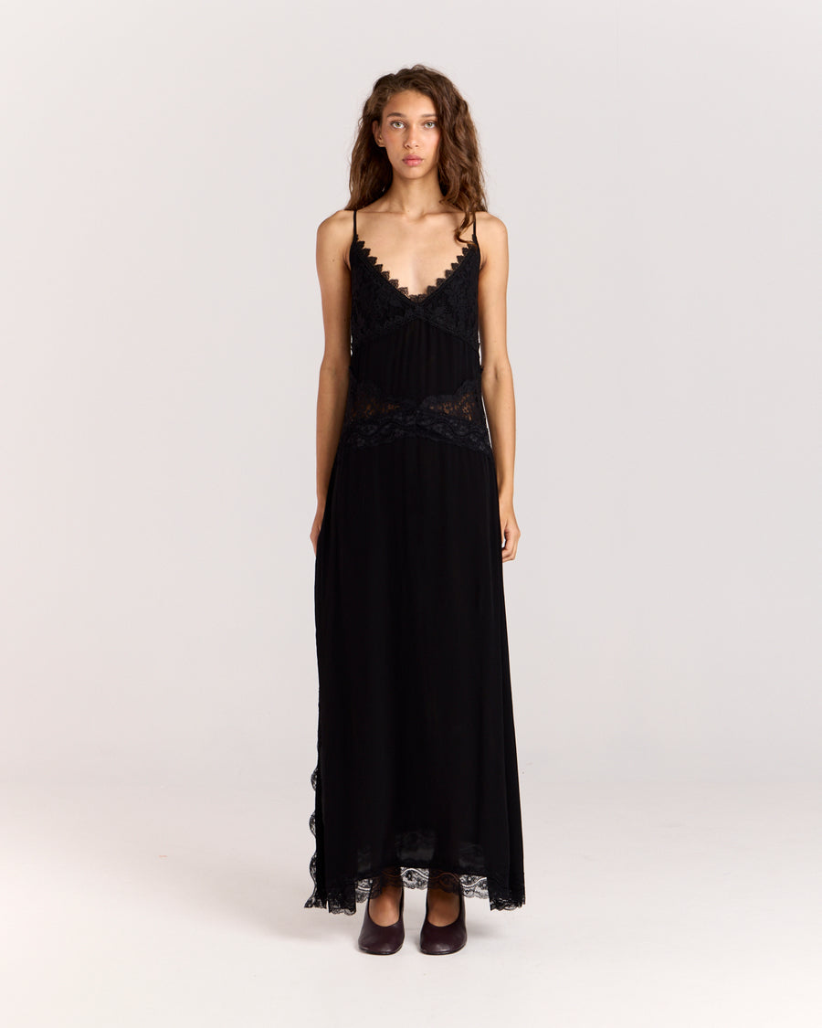 Step into elegance with this black maxi dress featuring contrast floral lace detail through the front to accentuate the waist. Crafted from matte satin, the relaxed silhouette falls gracefully with a side split and lace trim, finished with adjustable straps for a perfect fit.