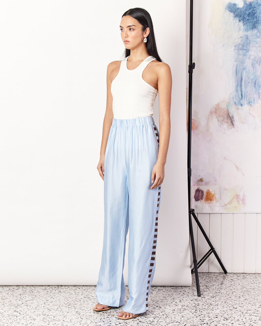 The Waterfront Pant is a relaxed style straight leg pant in a sky-blue colourway detailed with the Romy exclusive waterfront print. Crafted with a silky recycled viscose blend, the pants are slightly tailored, featuring an elastic waist band and side pockets with a matte finish.  Pair with the matching Waterfront Shirt to complete the set. 